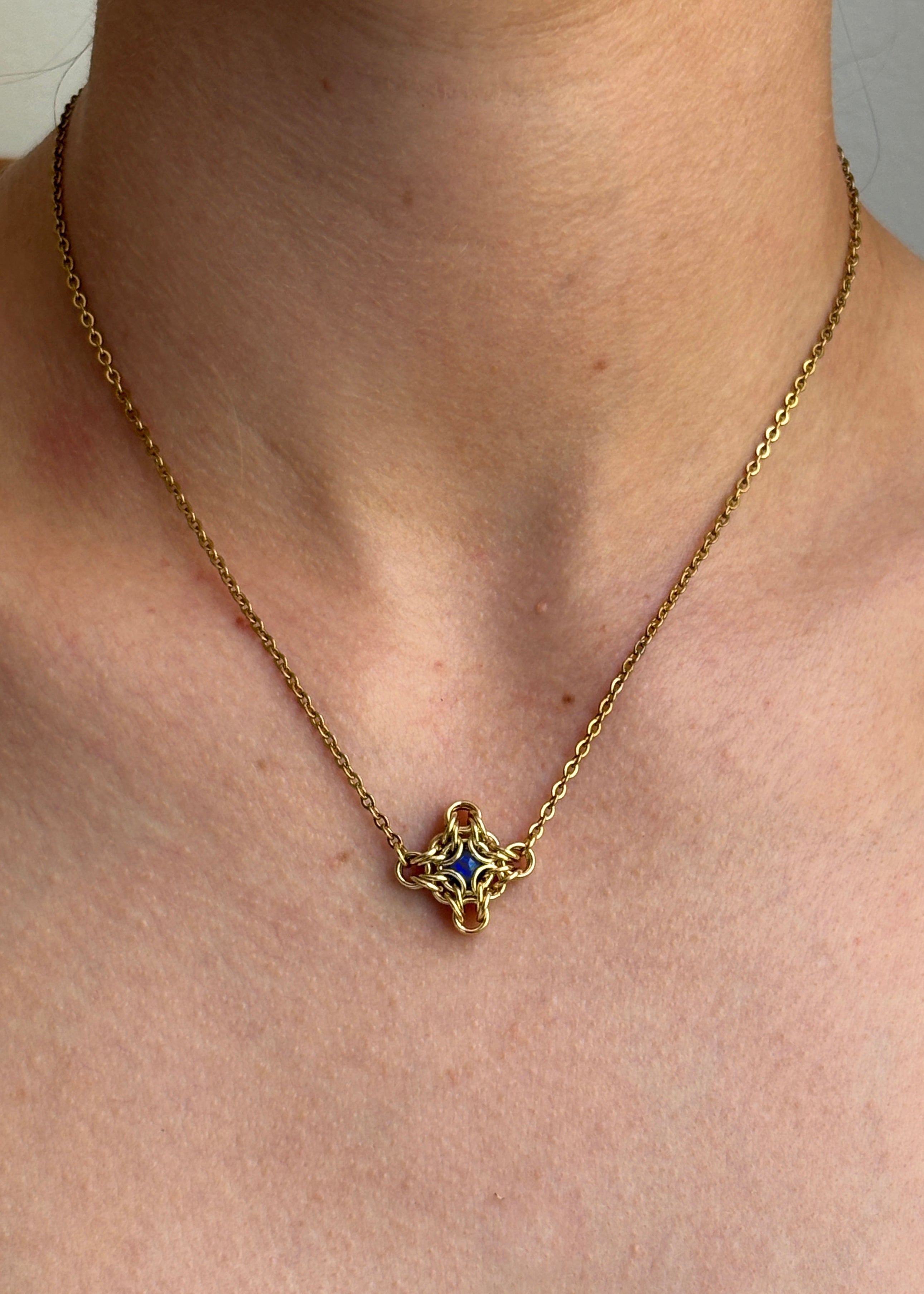 Gold necklace with a star-shaped pendant worn by a person